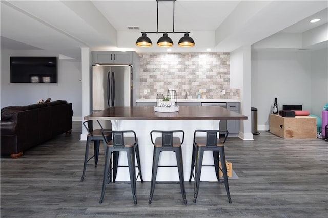 kitchen featuring open floor plan, appliances with stainless steel finishes, and a kitchen bar