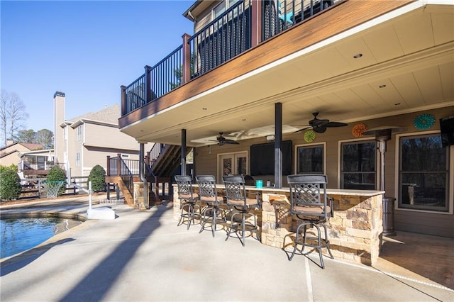 view of patio with an outdoor pool, ceiling fan, and outdoor dry bar