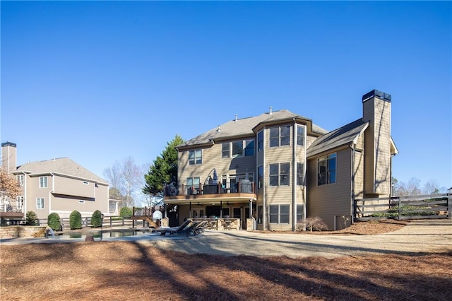 rear view of property with a patio area, fence, and a chimney