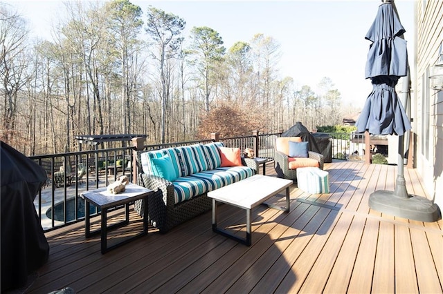 wooden deck with area for grilling and an outdoor living space