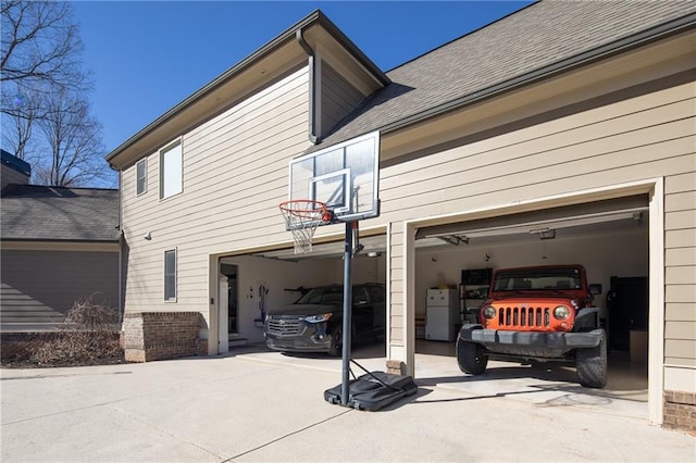 exterior space with freestanding refrigerator and driveway