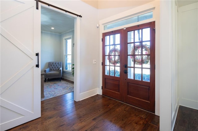 entryway featuring french doors, a barn door, and dark wood-type flooring