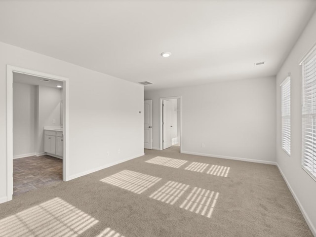 unfurnished bedroom featuring carpet flooring, visible vents, and baseboards