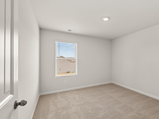 carpeted empty room featuring baseboards and visible vents