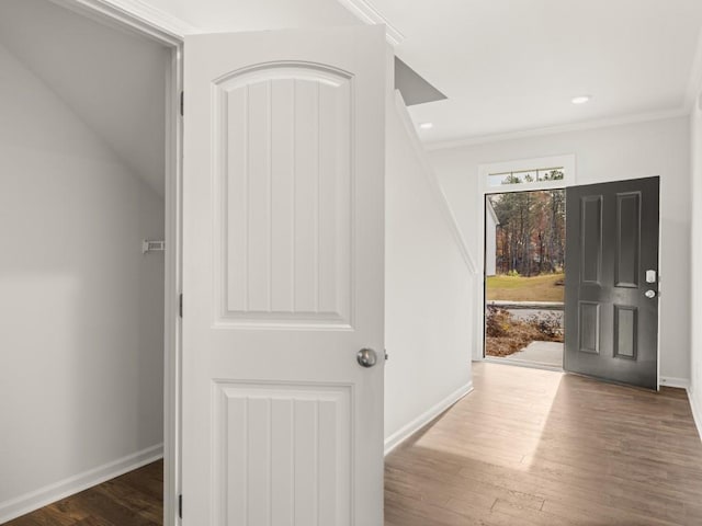 hall featuring recessed lighting, baseboards, wood finished floors, and ornamental molding