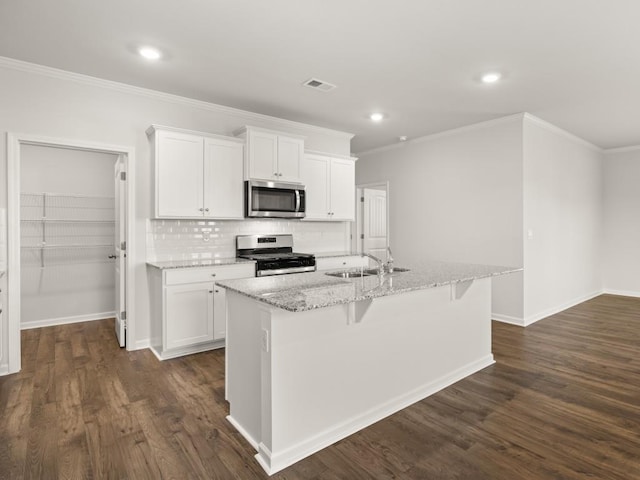 kitchen with appliances with stainless steel finishes, white cabinetry, a sink, and dark wood-type flooring