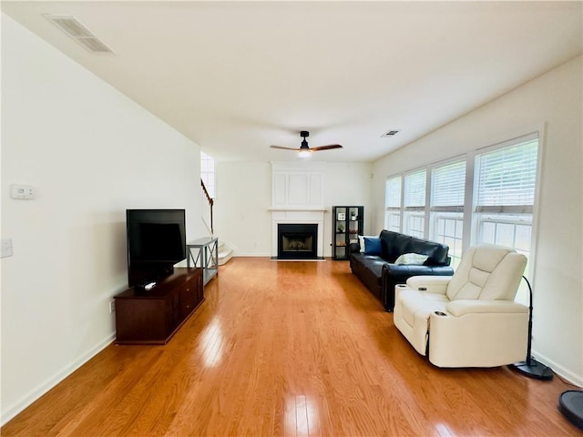 365 Friars Head Dr, Suwanee, GA 30024 - living area with light wood-style flooring, a ceiling fan, a large fireplace, and baseboards
