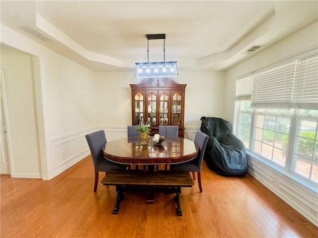 365 Friars Head Dr, Suwanee, GA 30024 - dining space featuring a raised ceiling, light wood-type flooring, and a wainscoted wall