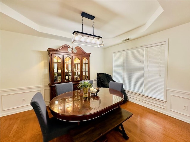365 Friars Head Dr, Suwanee, GA 30024 - dining room featuring a tray ceiling, wood finished floors, and wainscoting