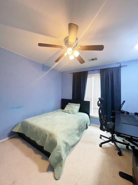 carpeted bedroom with ceiling fan and visible vents