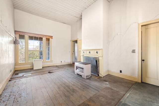 unfurnished living room featuring a fireplace, a high ceiling, and hardwood / wood-style flooring