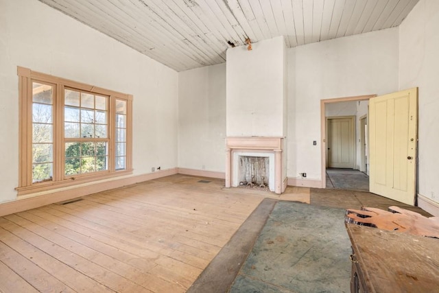 unfurnished living room with high vaulted ceiling, wooden ceiling, and light wood-type flooring