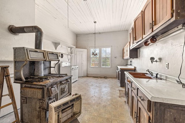 kitchen featuring a wood stove, sink, hanging light fixtures, white range oven, and wood ceiling