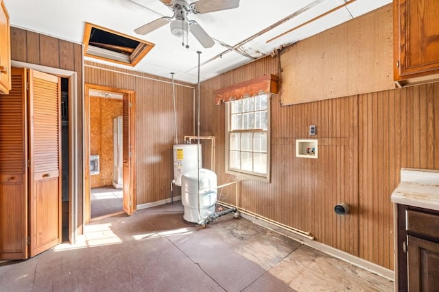 miscellaneous room with wooden walls, ceiling fan, and gas water heater