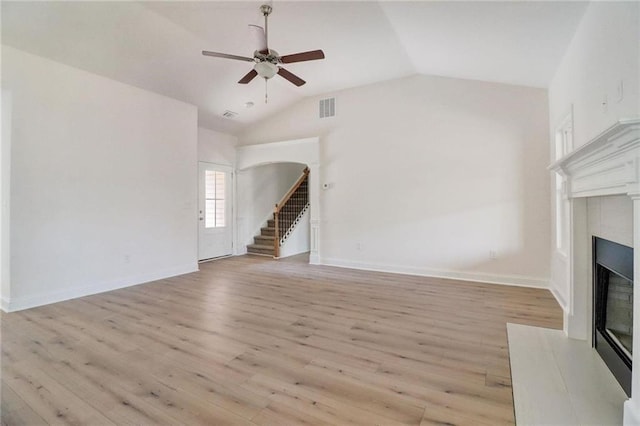 unfurnished living room featuring ceiling fan, lofted ceiling, and light wood-type flooring