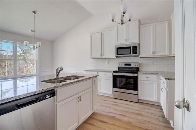 kitchen featuring an inviting chandelier, white cabinetry, stainless steel appliances, and sink