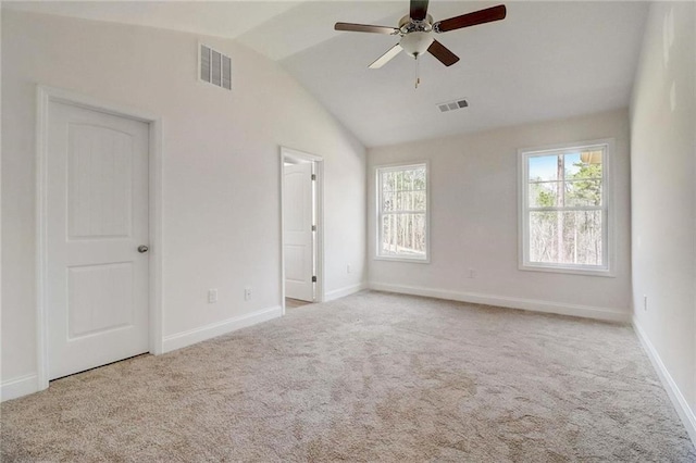 carpeted spare room featuring lofted ceiling and ceiling fan