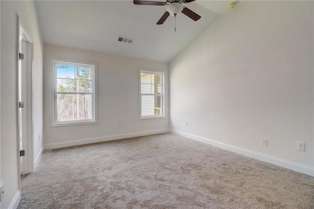 empty room featuring lofted ceiling, light colored carpet, and ceiling fan