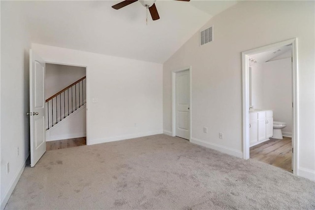 interior space featuring vaulted ceiling, light colored carpet, and ceiling fan