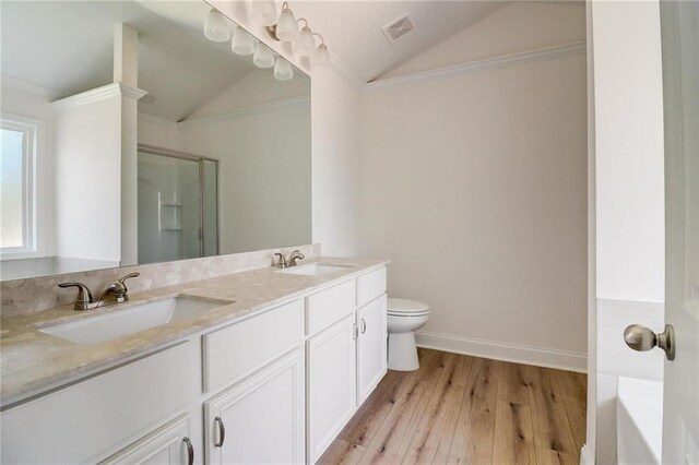 bathroom with lofted ceiling, hardwood / wood-style flooring, walk in shower, toilet, and crown molding