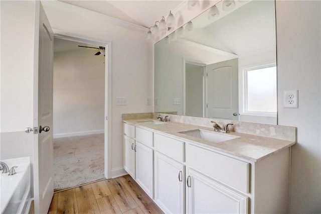 bathroom featuring hardwood / wood-style flooring, vanity, a washtub, and ceiling fan