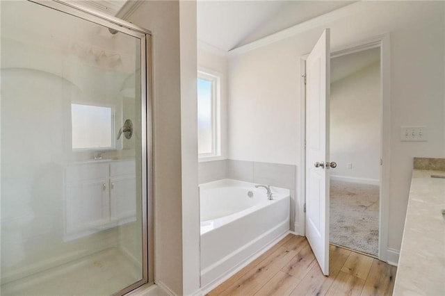 bathroom with hardwood / wood-style flooring, vanity, lofted ceiling, and independent shower and bath