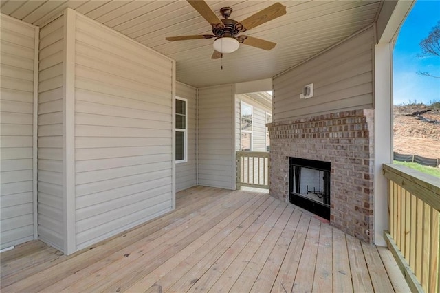 wooden terrace featuring an outdoor brick fireplace and ceiling fan