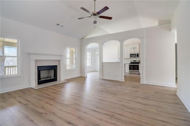 unfurnished living room with ceiling fan, plenty of natural light, light wood-type flooring, and a fireplace