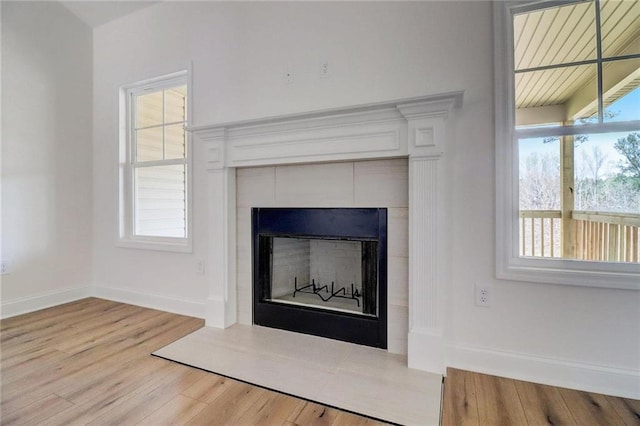 room details featuring wood-type flooring and a tiled fireplace