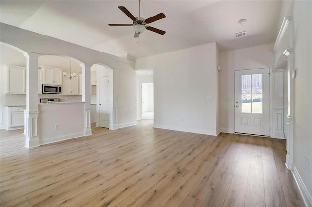 unfurnished living room featuring ceiling fan, vaulted ceiling, and light wood-type flooring