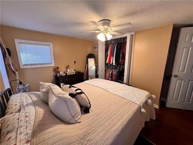 bedroom featuring a textured ceiling, dark wood-type flooring, a closet, and ceiling fan