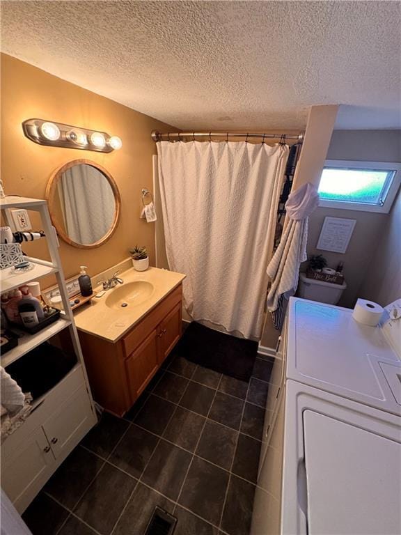 bathroom with vanity, washer / dryer, a textured ceiling, and a shower with curtain