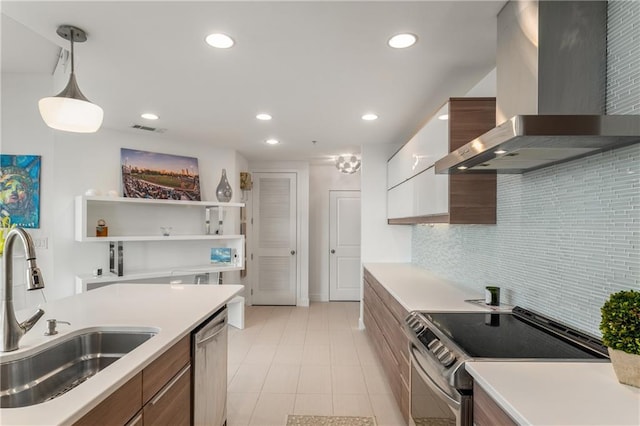 kitchen with decorative light fixtures, ventilation hood, sink, white cabinets, and stainless steel appliances