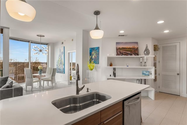 kitchen featuring expansive windows, sink, an inviting chandelier, dishwasher, and pendant lighting