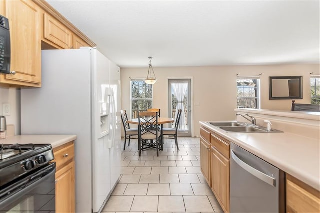 kitchen featuring black appliances, decorative light fixtures, light brown cabinets, and sink