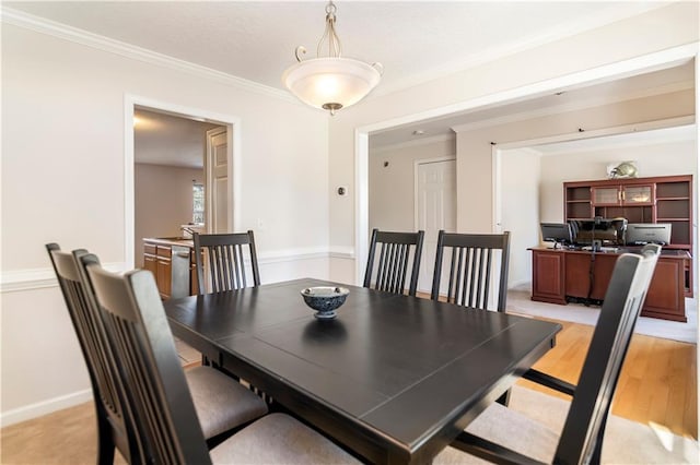 dining area with light hardwood / wood-style floors and ornamental molding