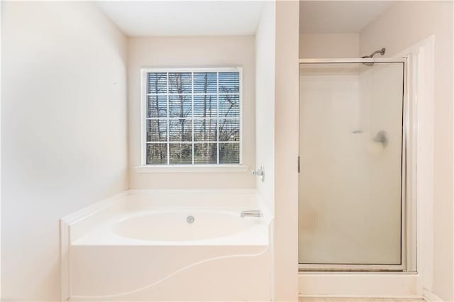 bathroom featuring shower with separate bathtub