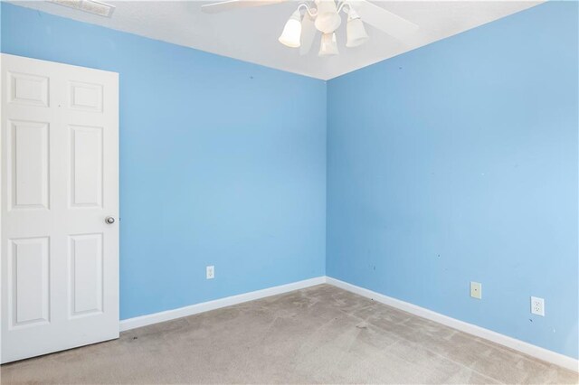 carpeted spare room featuring ceiling fan