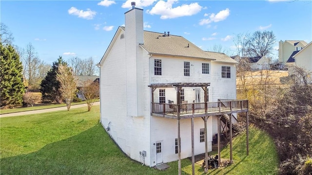 rear view of house featuring a pergola, a wooden deck, and a lawn