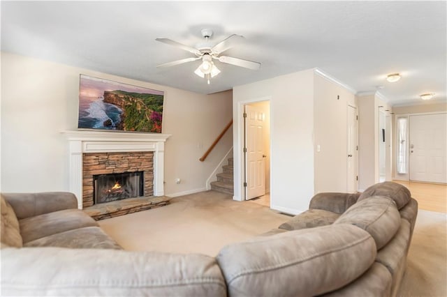 carpeted living room with a fireplace, ceiling fan, and crown molding