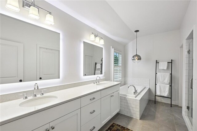 full bath featuring a sink, a garden tub, a stall shower, and double vanity