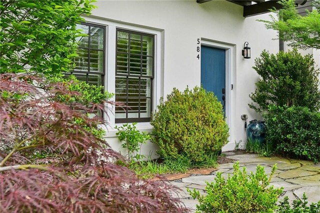 view of exterior entry with stucco siding