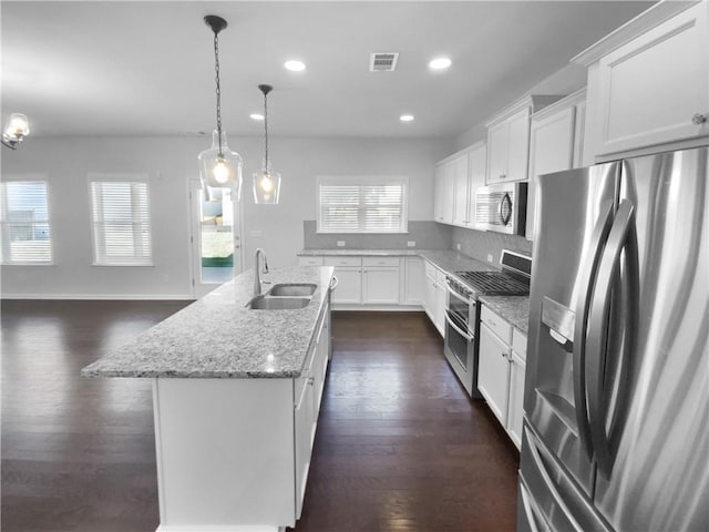 kitchen with a center island with sink, stainless steel appliances, visible vents, white cabinetry, and a sink