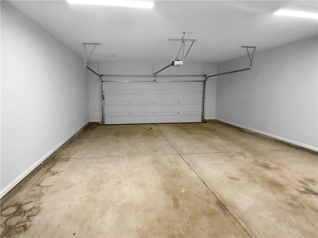 garage featuring a garage door opener and baseboards
