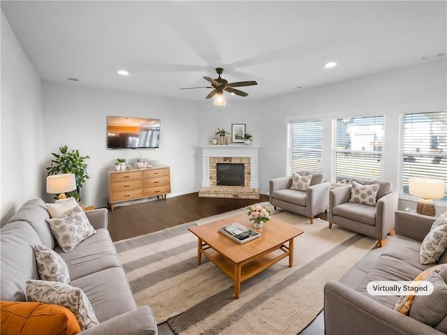 living room featuring ceiling fan, recessed lighting, a fireplace, and wood finished floors