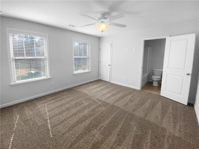 unfurnished bedroom with visible vents, connected bathroom, baseboards, and carpet flooring