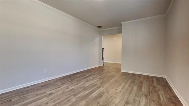 empty room with hardwood / wood-style flooring and ornamental molding