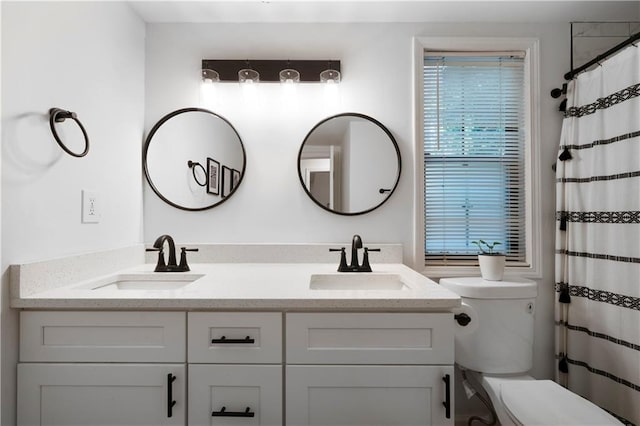 bathroom with curtained shower, toilet, and vanity