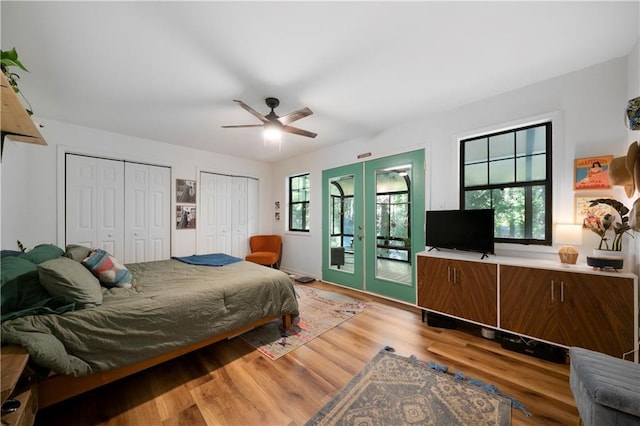 bedroom with hardwood / wood-style flooring, ceiling fan, french doors, and multiple windows