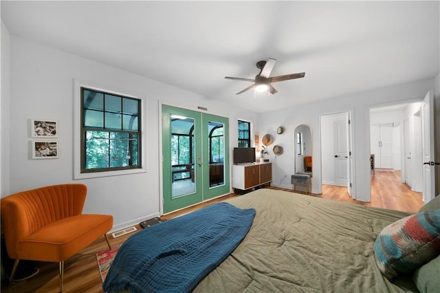 bedroom featuring ceiling fan, access to exterior, french doors, and light wood-type flooring